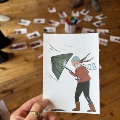 Eine Emotionskarte im Vordergrund und im Hintergrund das ganze Kartenset im Workshopraum bei einem Teamcoaching