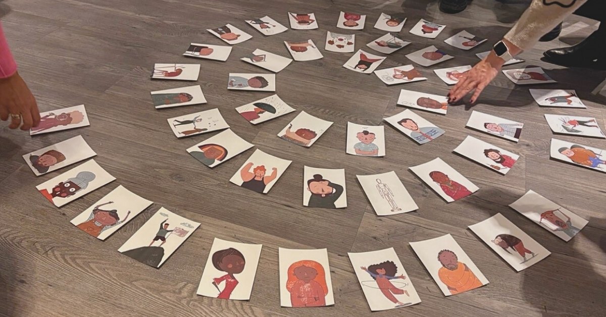 49 Gefühlskarten für Erwachsene in einer Spirale auf dem Boden in einem Workshopraum.