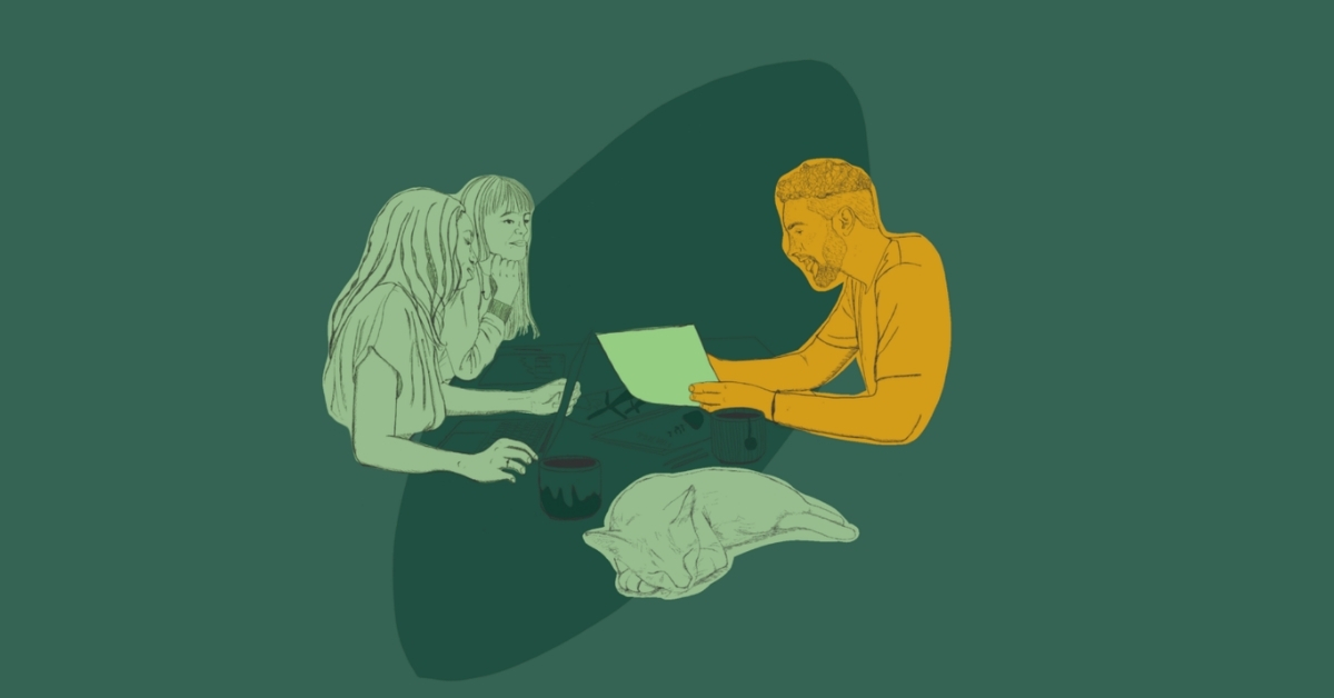 Two women and a man sitting at a desk. They are looking together at documents in the middle of the table.