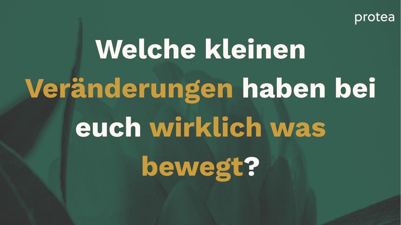 Eine Workshop Teilnehmerin erhält Material, die Gruppe schaut zu. 