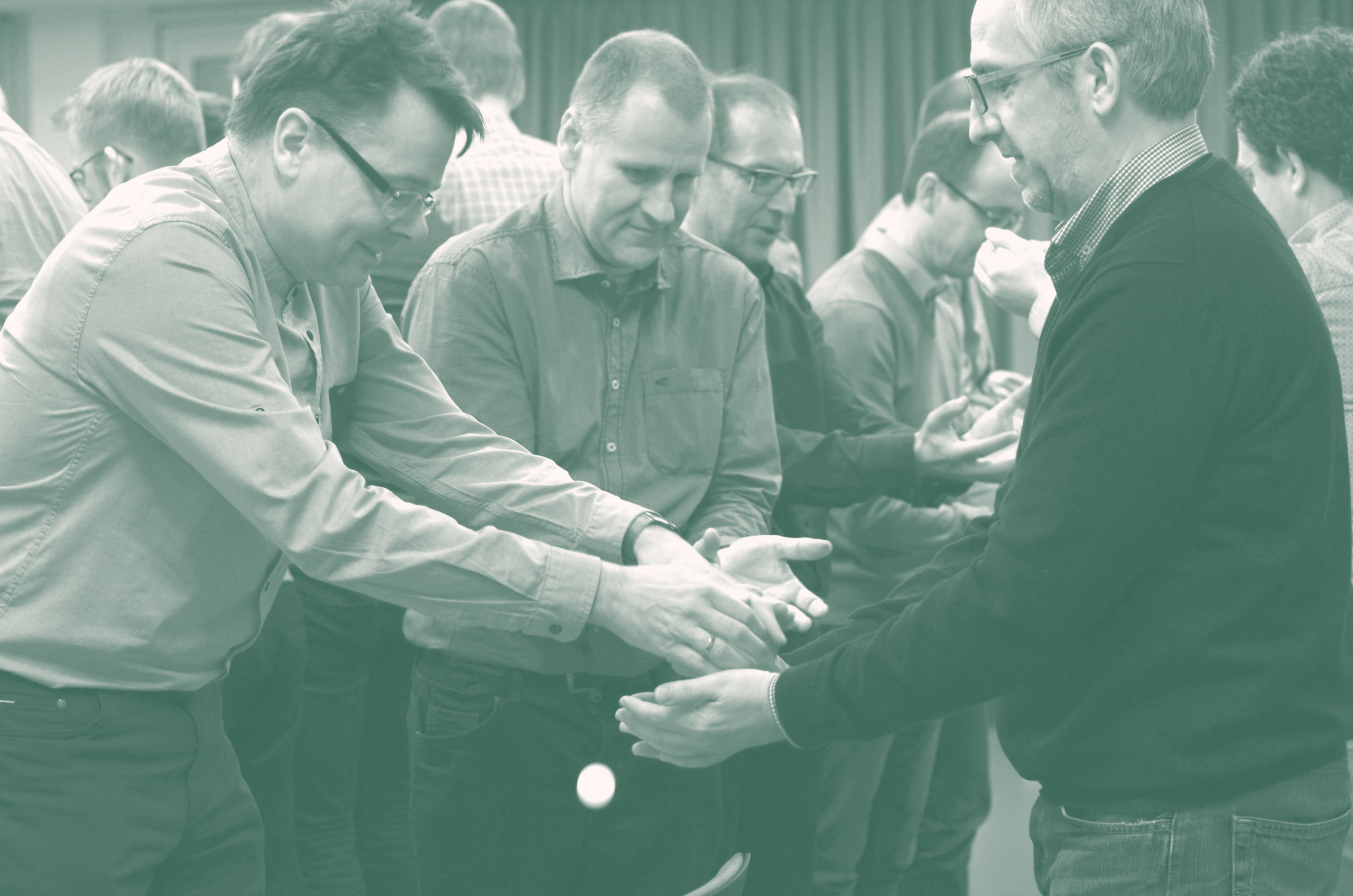 Teilnehmende eines Workshops arbeiten in Kleingruppen interaktiv an einer Übung zur Team- und Vertrauensbildung.