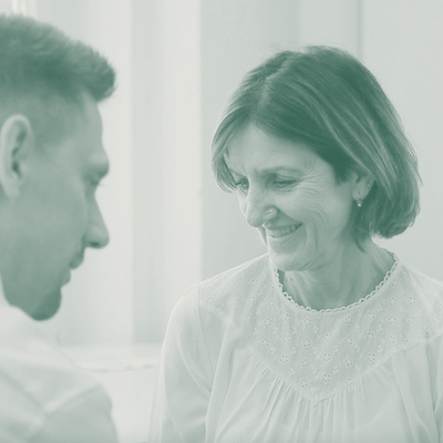 Resilienz Training für Führungskräfte Eine Frau und ein Mann im vertrauensvollen Gespräch: Nähe, Aufmerksamkeit, Augenhöhe.